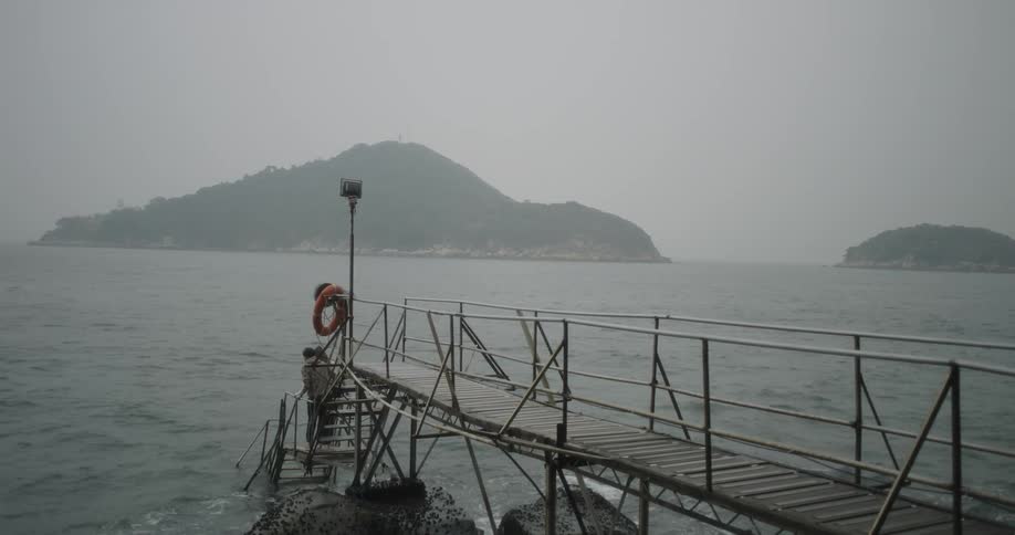 A man and woman climb down the steps of the pier towards the water