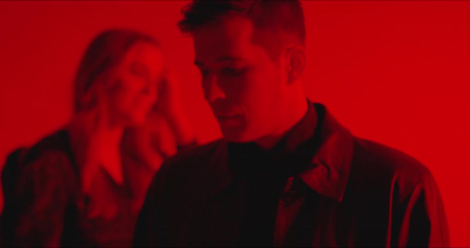 Man and woman standing in room with flashing blue and red lights
