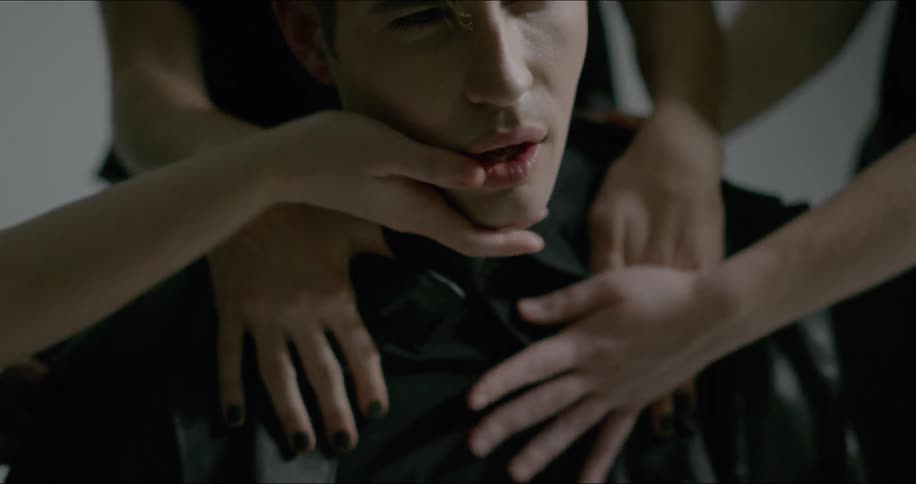 Hands touch and caress a man's face and chest