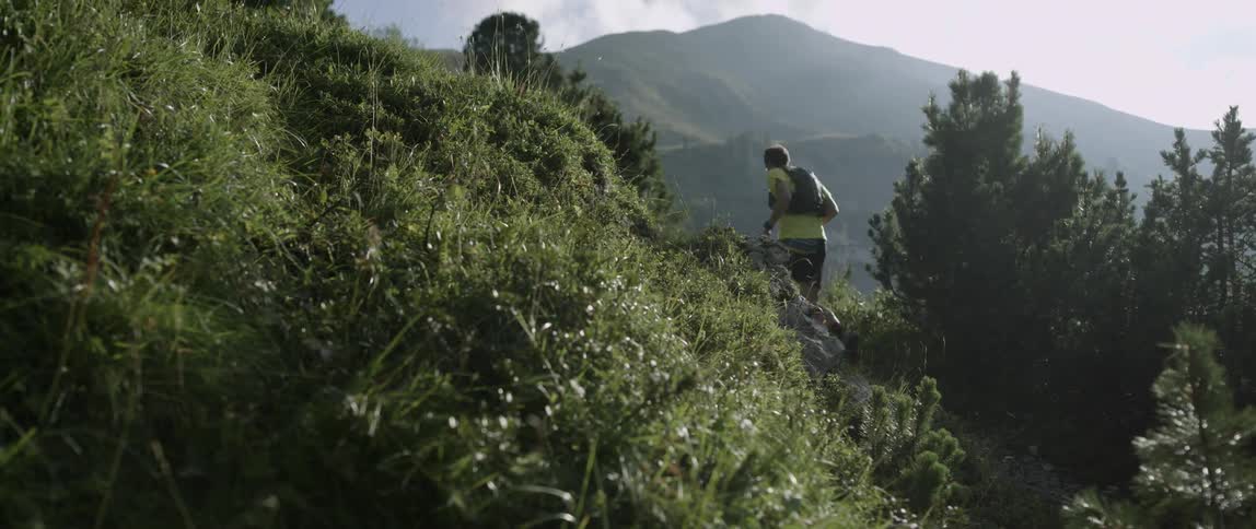 A man runs up the trail on a mountain