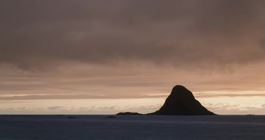 A rocky mountain island in the sea in time lapse