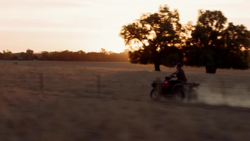 A man is riding a four wheeler down the trail