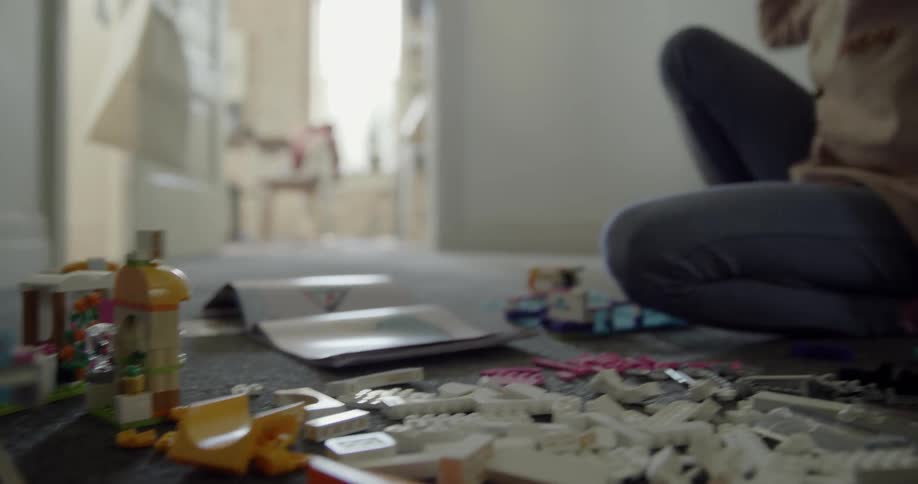 A child is playing with toys in her bedroom