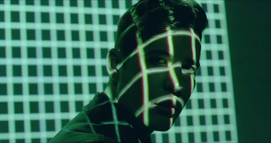 A man has a light grid moving over his face