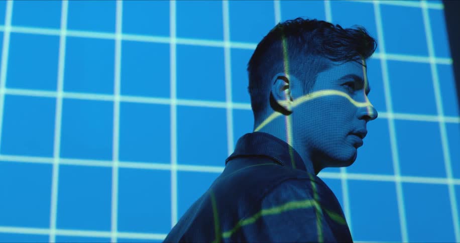 Grid lights project onto a wall and man's face