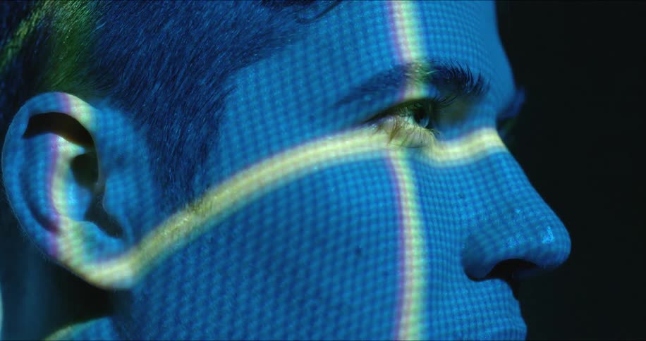 A man is in a dark room with lights flashing on his face