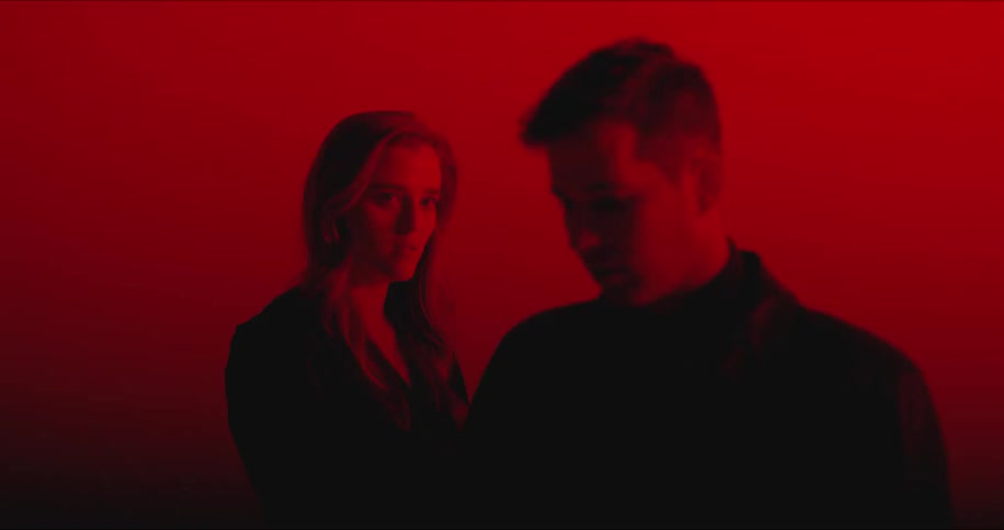 A woman is standing behind a man with lights flashing