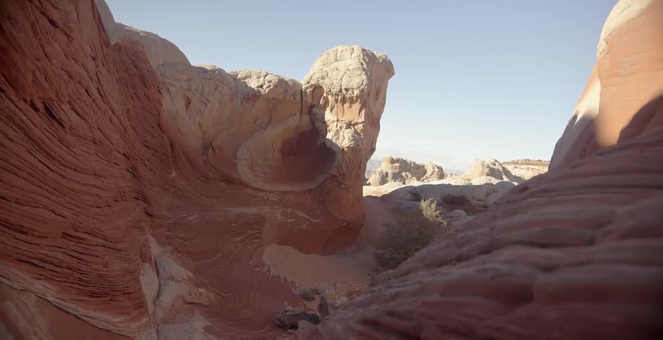A red rock formation stands in the desert on a sunny day