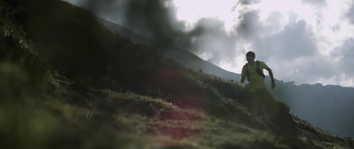 Person jogs up a grassy hill