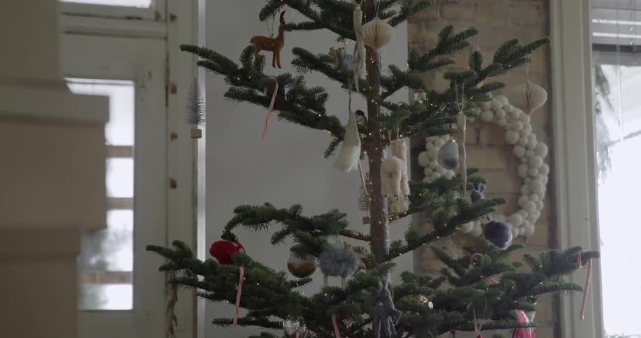 A small christmas tree is in the corner of this home