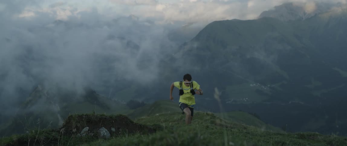 A man is running uphill on a foggy day
