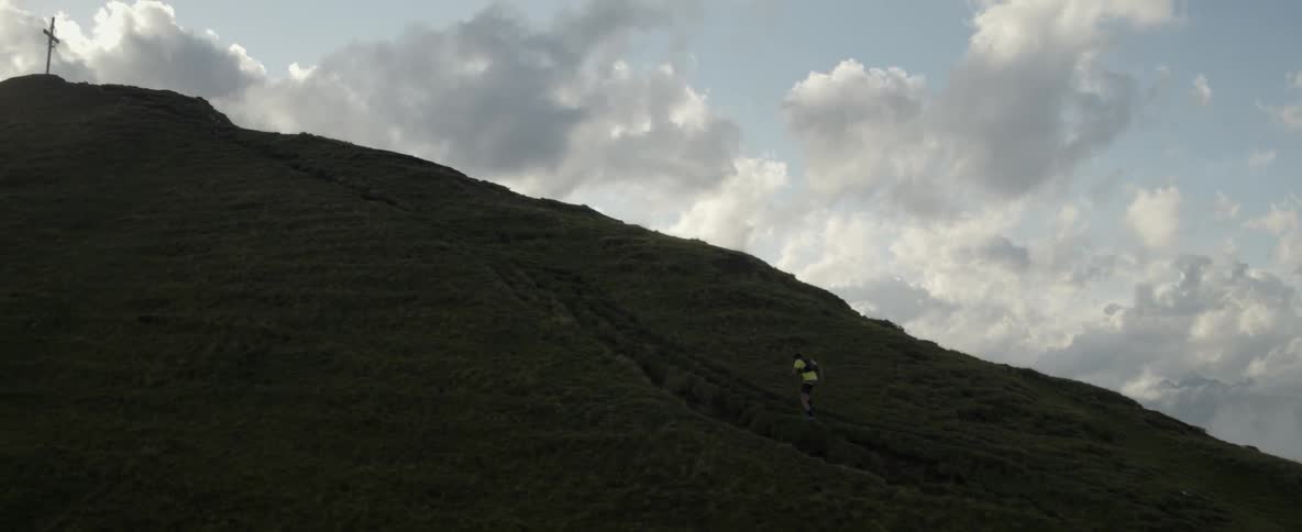 A man is running fast up a steep mountain
