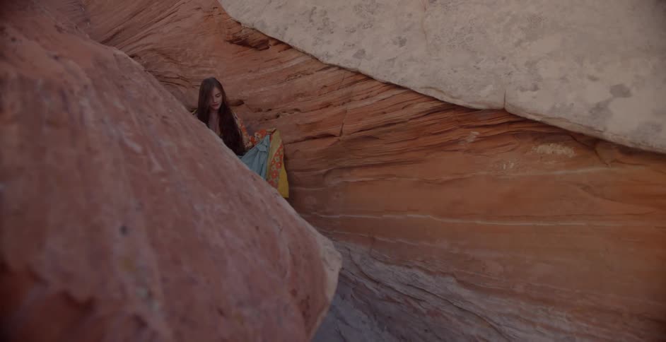 Woman walks through formation of rocks