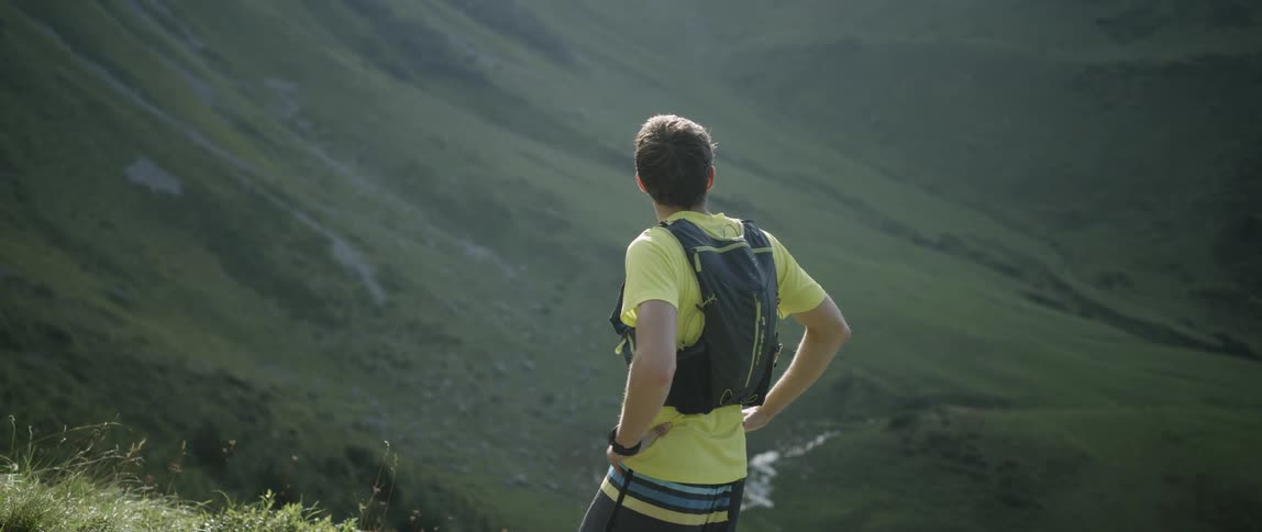A man is standing on a hill taking in the view