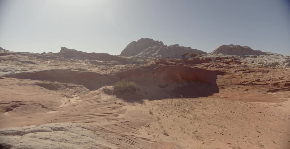 The sun shines over rock formations in the desert