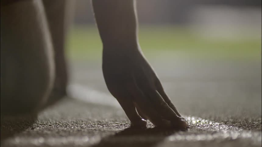 A person kneels down on the running line