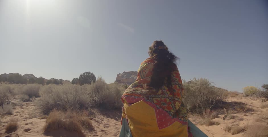 A woman is running in the desert on a sunny day