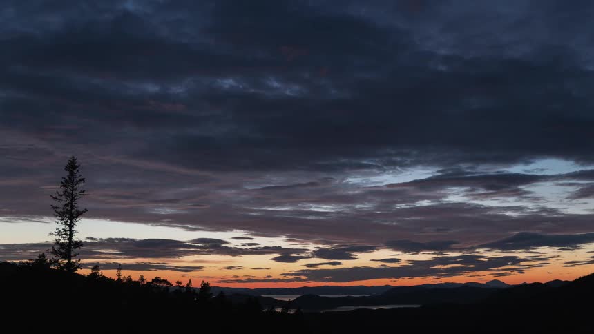 The dawn sky has many clouds moving over the horizon