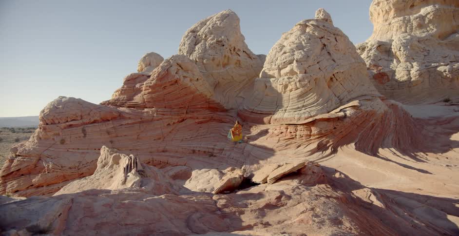 Woman walks through formation of rocks
