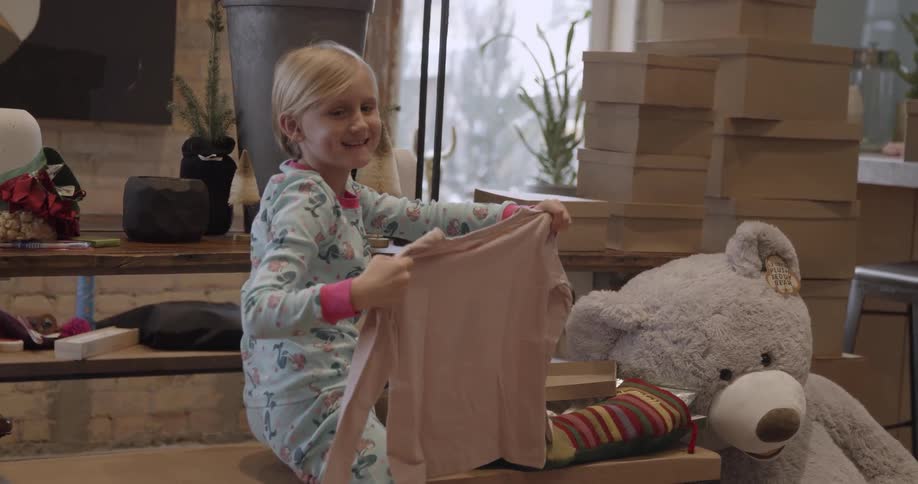 A girl holds up and shows a shirt