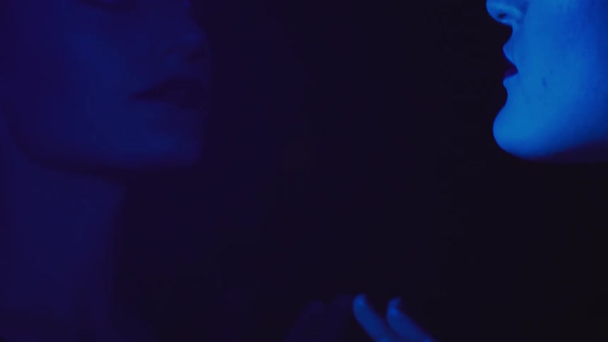 A woman looking at her reflection and the image is blue