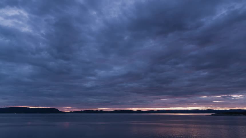 A bluish purple sky over some calm water