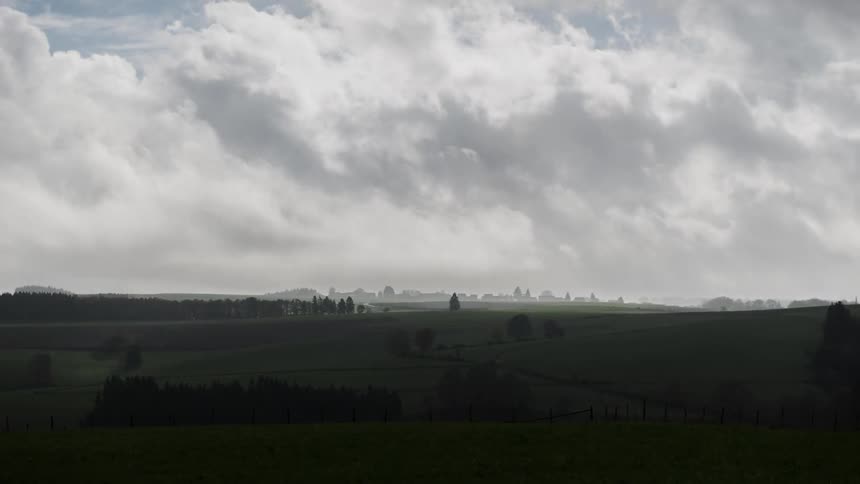 Heavy white clouds race over the field