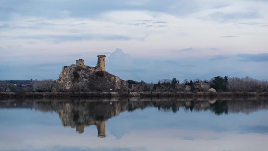 Clouds pass above a lake and old castle