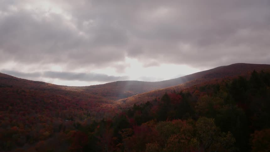 The sun peaks in ahead onto the hills from the clouds
