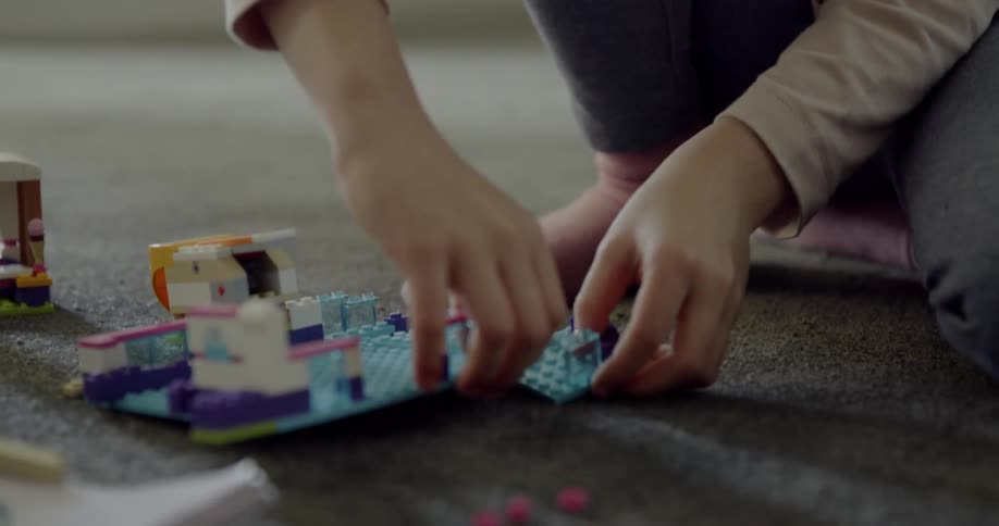 Child plays with legos on the floor