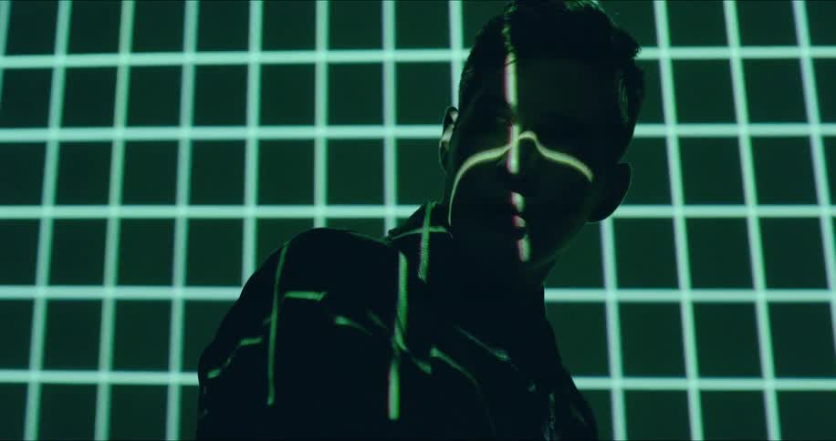 A man is looking to the side as lights flash on him