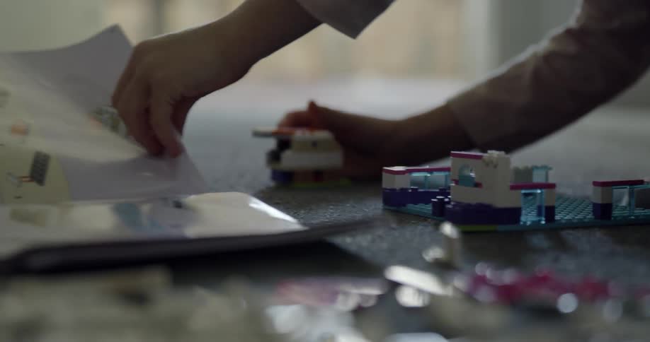 A child plays with legos on the floor