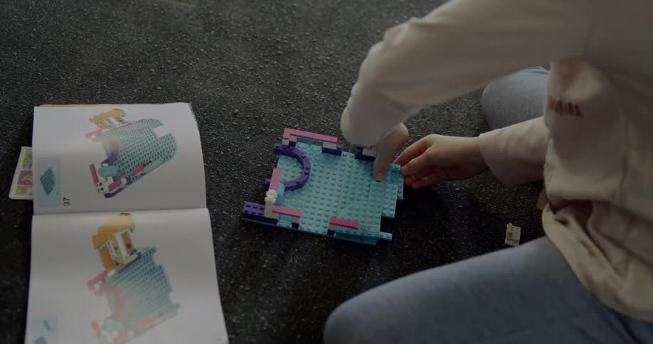 A child is building legos on the floor