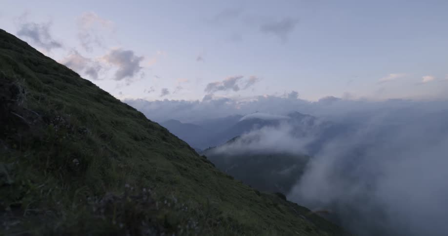 A bank of clouds clears from a mountainside in the morning