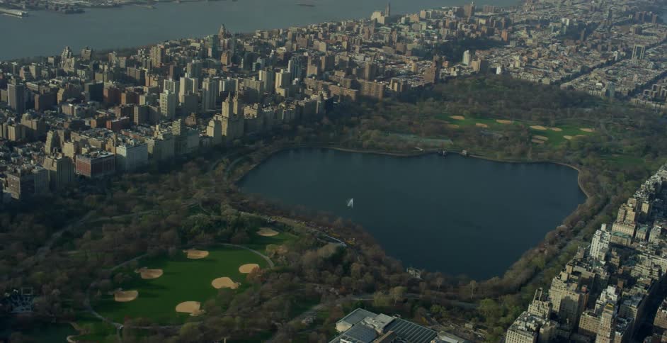 Buildings surround a park and lake