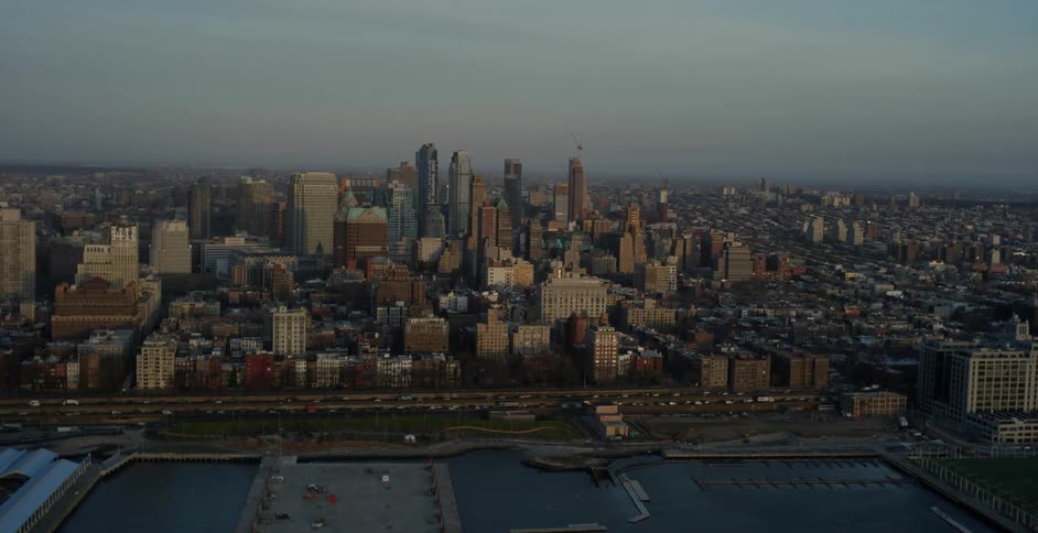 View of a large city and a road with many cars on a cloudy day
