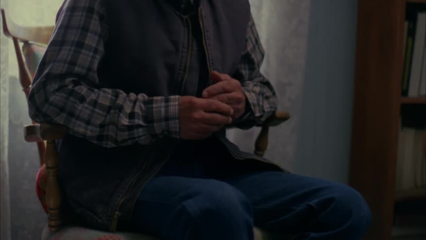 A person sits in a seat rubbing hands together