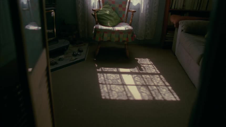 Shadow on ground of curtains hanging in window in living room