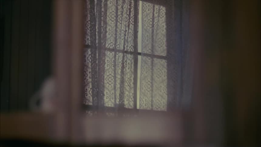 Wind blowing curtains in window in a house