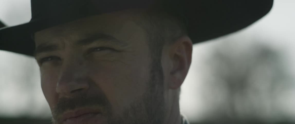 A cowboy stands outside