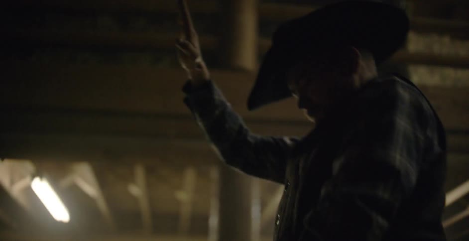 Cowboy riding mechanical bull in barn