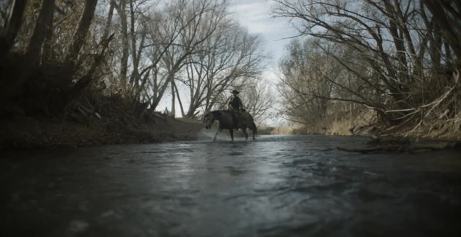 Man riding horse in shallow river water