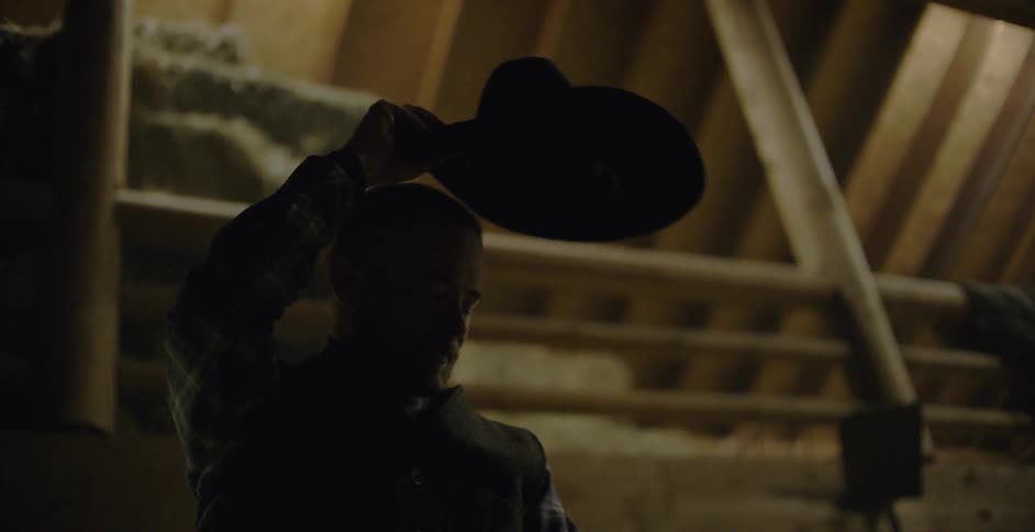 A cowboy takes off his hat