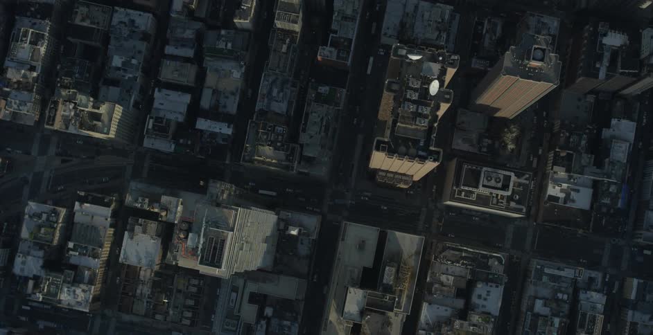 Aerial view of the tops of large buildings and cars on a street