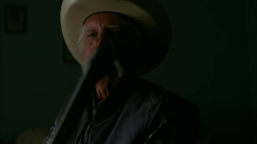 A man looks forward wearing a cowboy hat