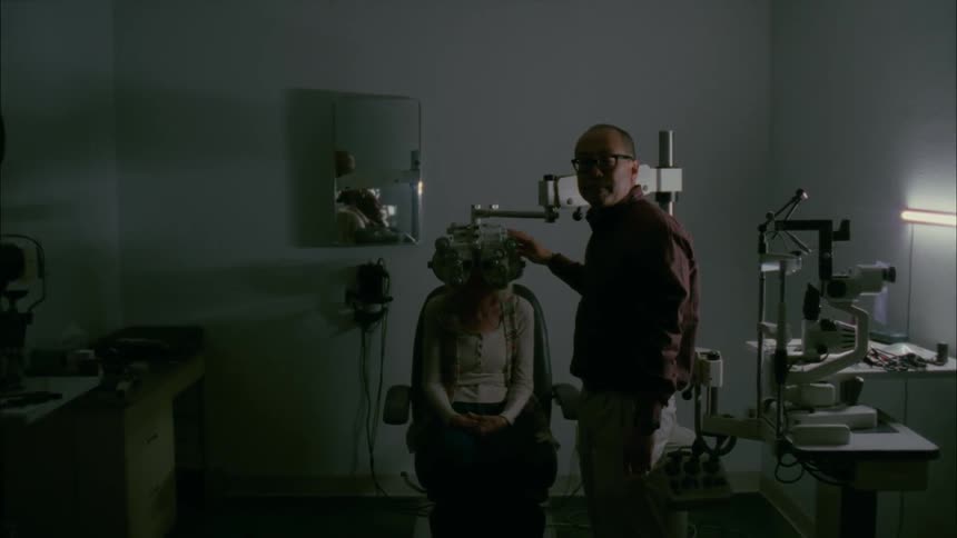 A woman is getting her eyes checked at the doctor
