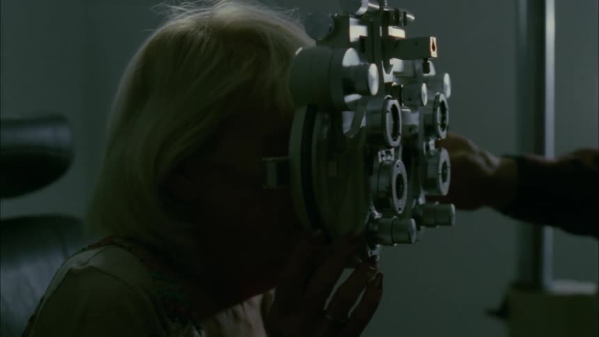 An old woman is having her eyes checked in an optometrist's office