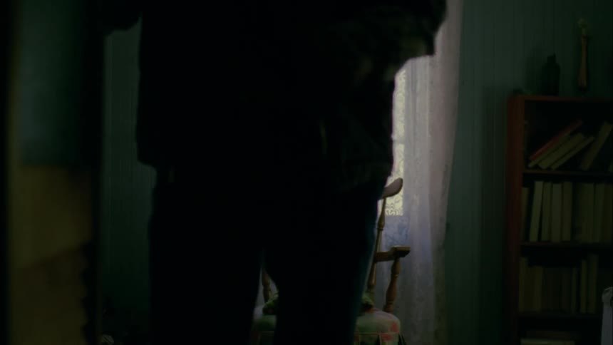 An old man gets up hurriedly from a rocking chair