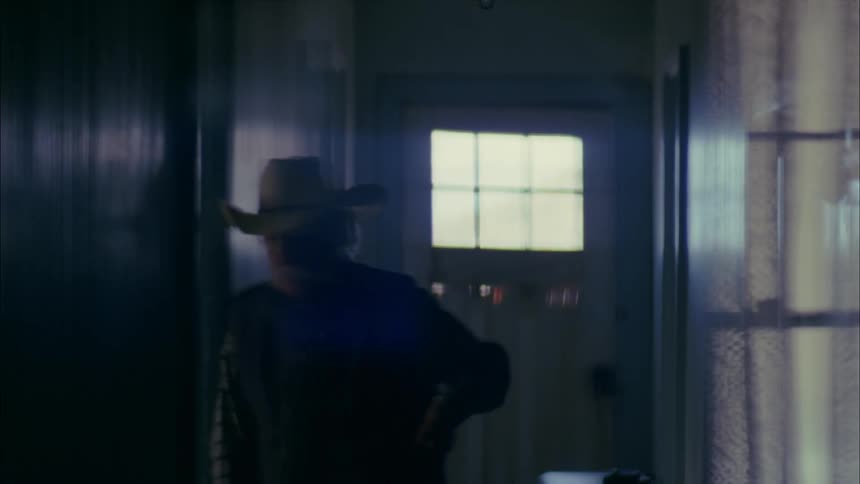 Older man standing in hallway lights cigarette and starts smoking