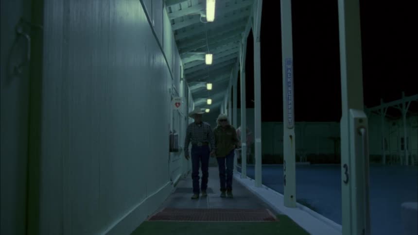Couple walks out of an industrial building at night